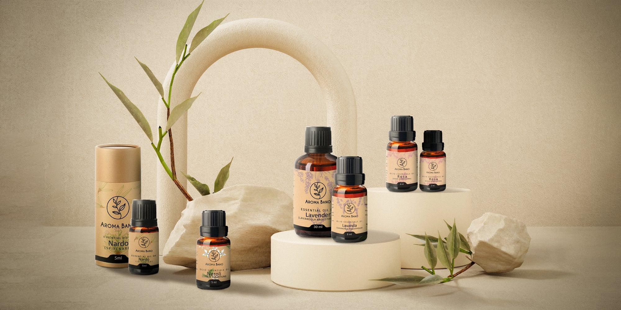 Oli essenziali Aroma Bano in diverse bottiglie con elementi naturali, rappresentazione della composizione e degli utilizzi degli oli essenziali