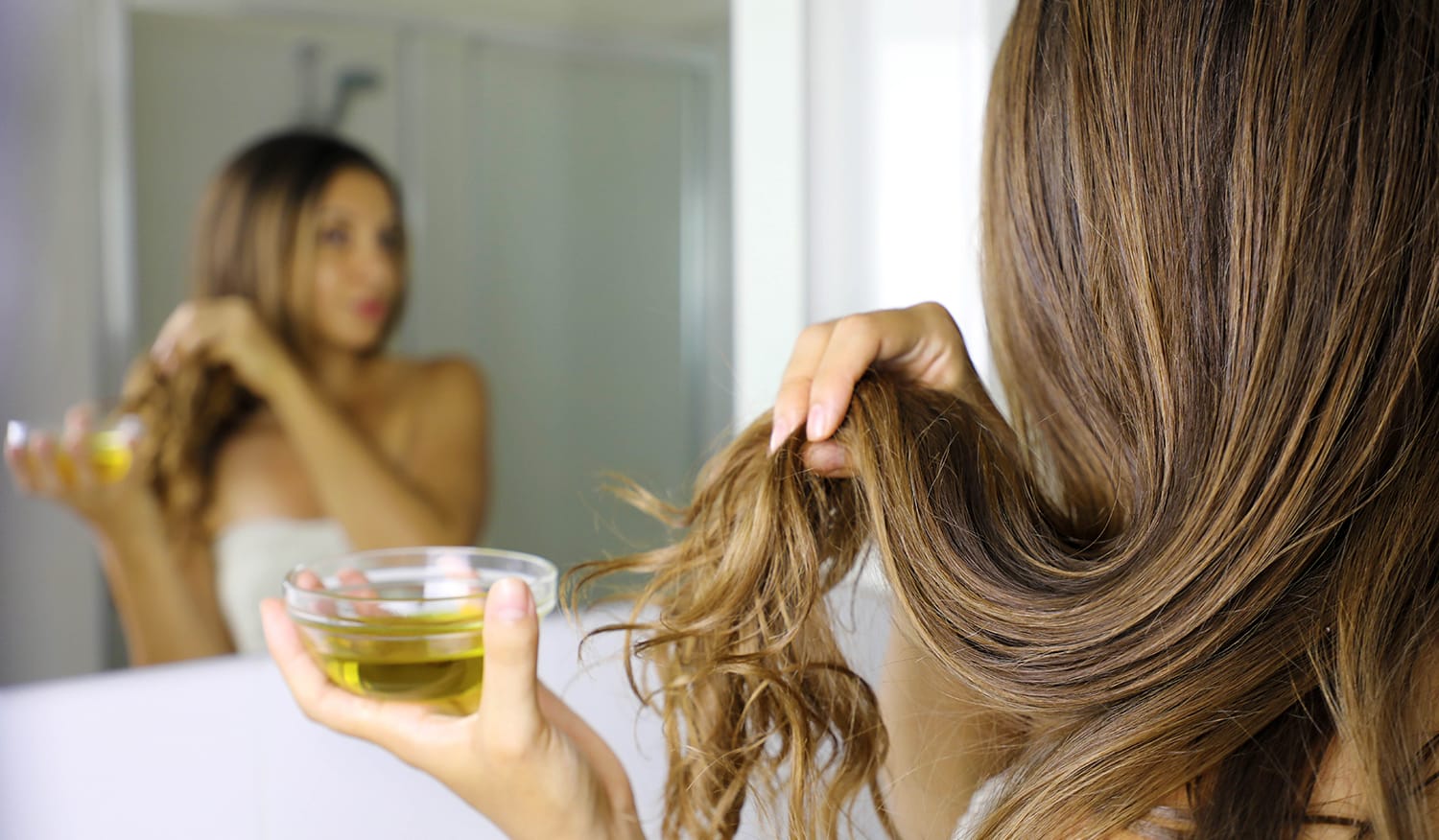 Applicazione di oli essenziali sui capelli per nutrire, rinforzare e migliorare la salute dei capelli