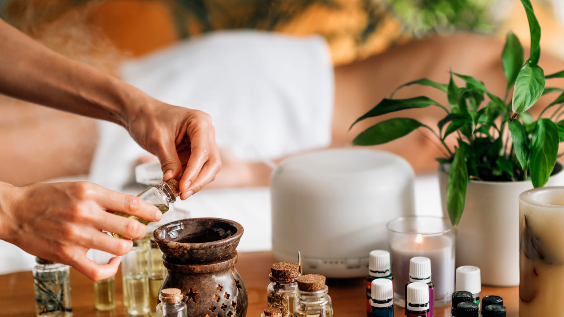 Diffusione di oli essenziali per aromatherapy con diffusore, candele e flaconi di essenze naturali in ambiente rilassante