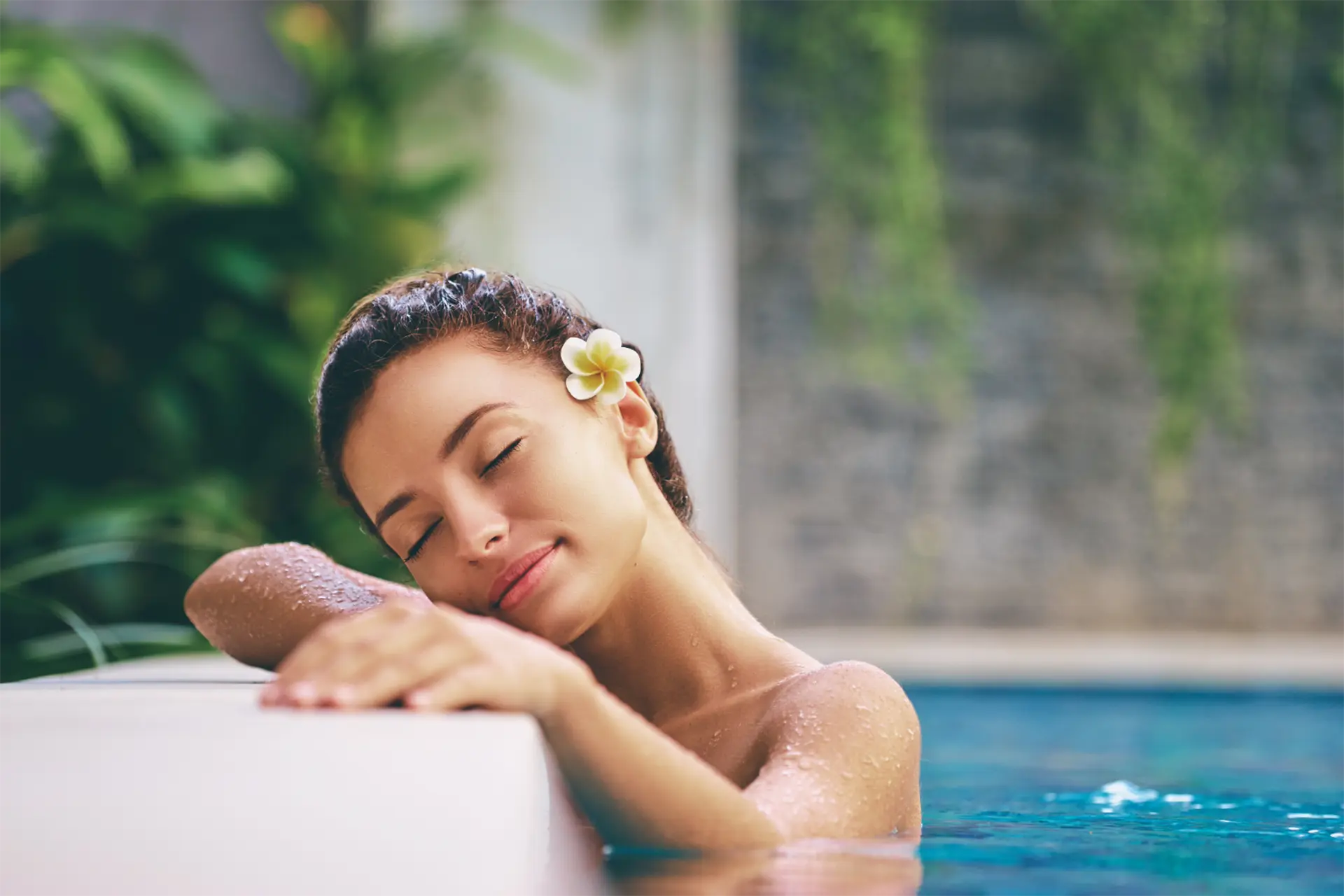 Woman relaxing in a spa pool surrounded by a peaceful wellness environment