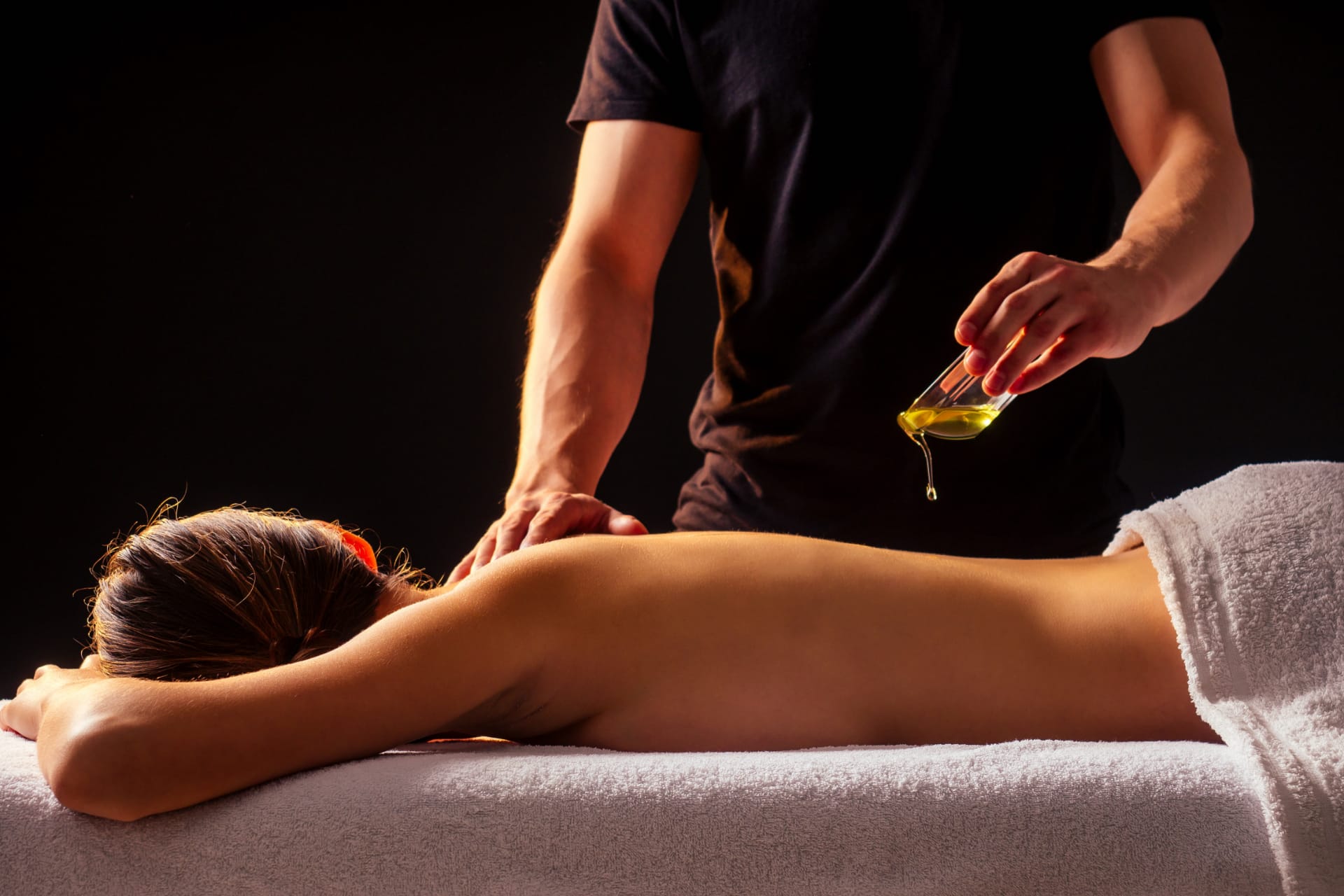 Applicazione di olio essenziale durante un massaggio rilassante per il benessere del corpo