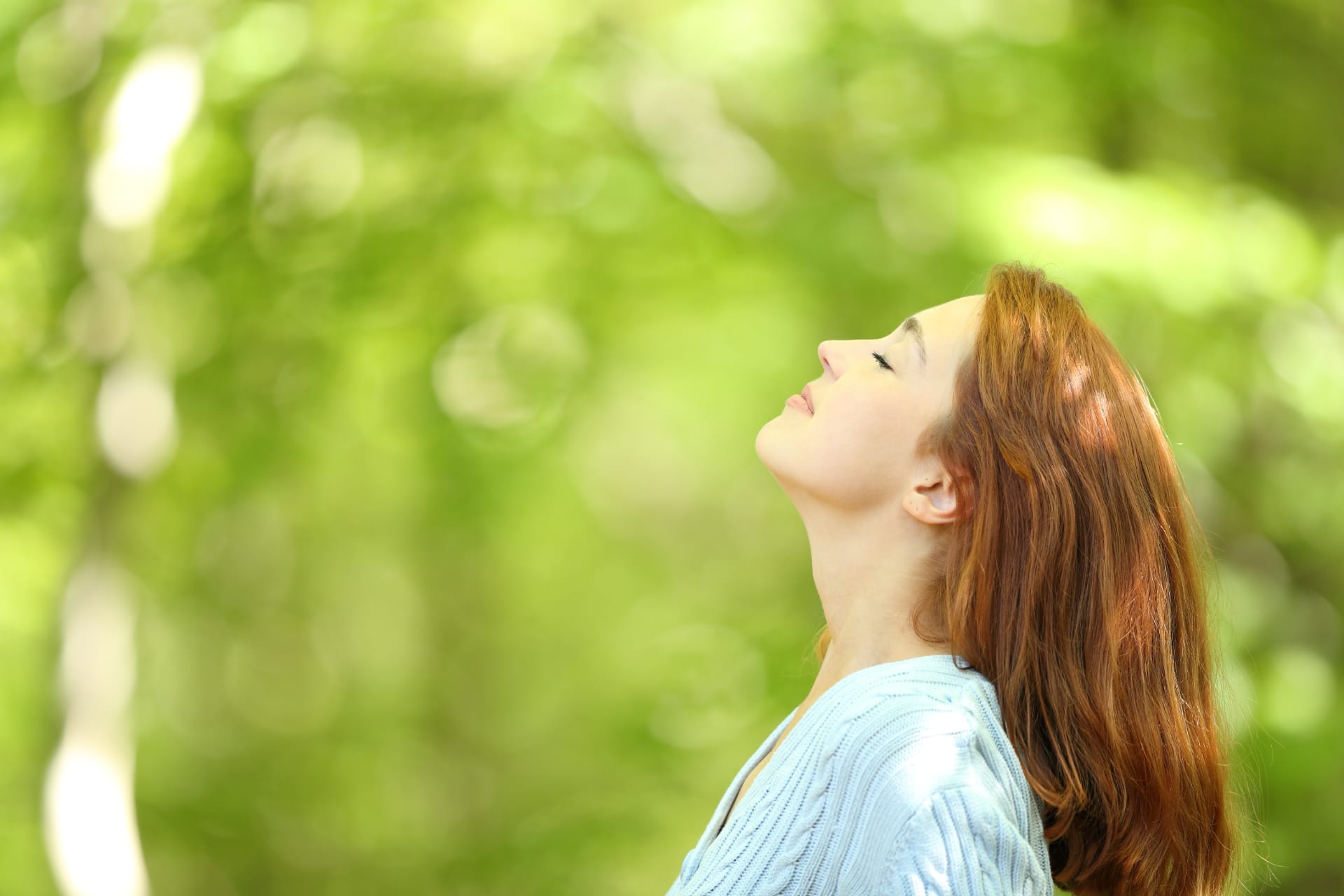 Donna che respira profondamente per favorire una sensazione di sollievo e benessere con oli essenziali
