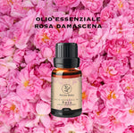 Olio essenziale di Rosa Damascena Aromabano su sfondo di petali di rosa.