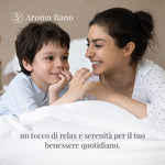 Donna e bambino sdraiati su un letto che condividono un momento di tranquillità in casa, legato all’uso dell’olio essenziale di alloro Aroma Bano da 8 ml