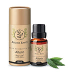 Confezione cilindrica e bottiglia da 8 ml di olio essenziale di alloro Aroma Bano affiancate a foglie verdi di alloro
