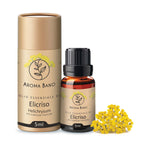 Confezione e bottiglia da 5 ml di olio essenziale di Elicriso Aroma Bano affiancate da fiori di elicriso