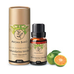 Confezione cilindrica e bottiglia da 8 ml di olio essenziale di Mandarino Verde Aroma Bano affiancate al frutto fresco