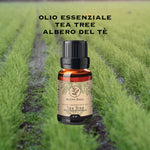 Olio essenziale di Tea Tree con flacone su piantagione di tea tree